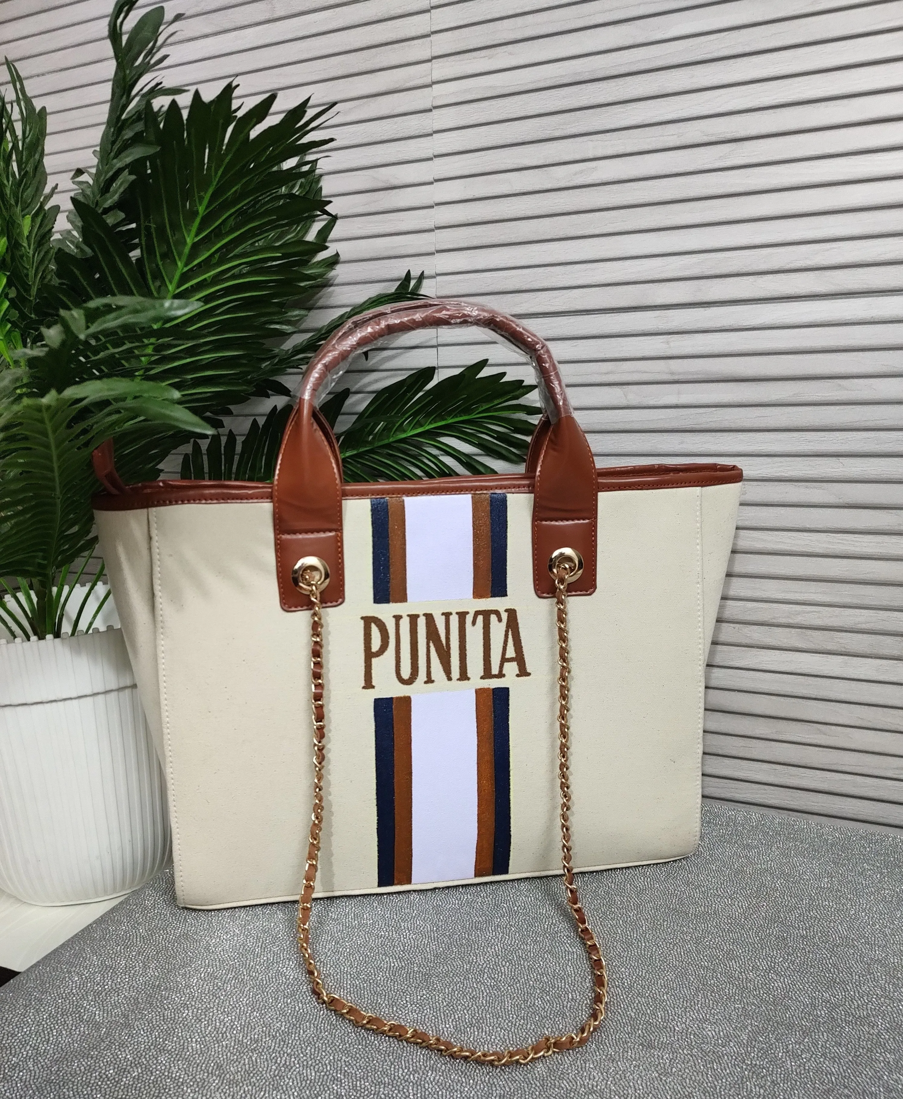 Off white bag with navy blue, brown and white stripes